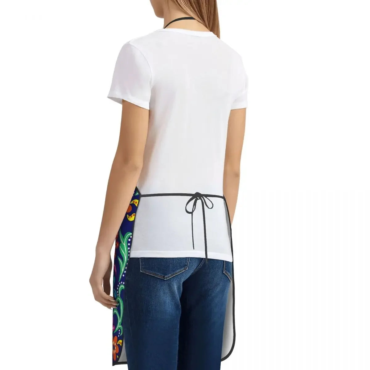 White t-shirt with a black floral art apron tied around the waist, worn over dark blue jeans.