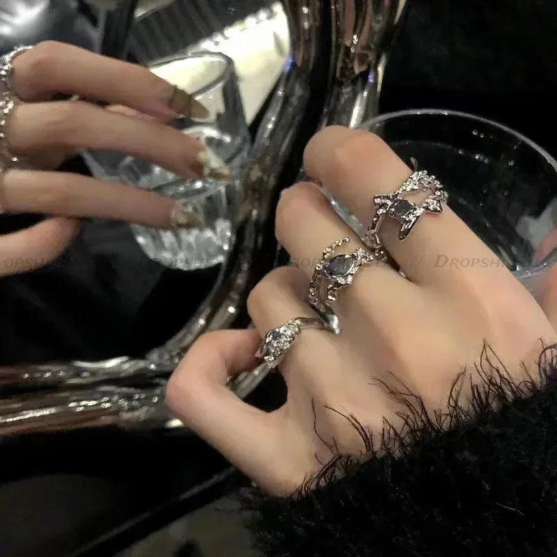 A close-up of a hand wearing an irregular heart-shaped silver ring on the finger.