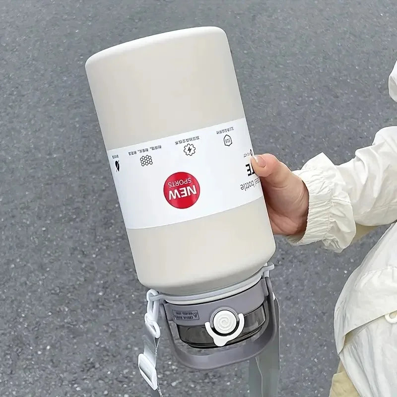A hand holds a white insulated stainless steel tumbler with a lid and straw, featuring a NEW Sports label.