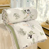 White comforter with a panda print featuring green foliage and lace trim