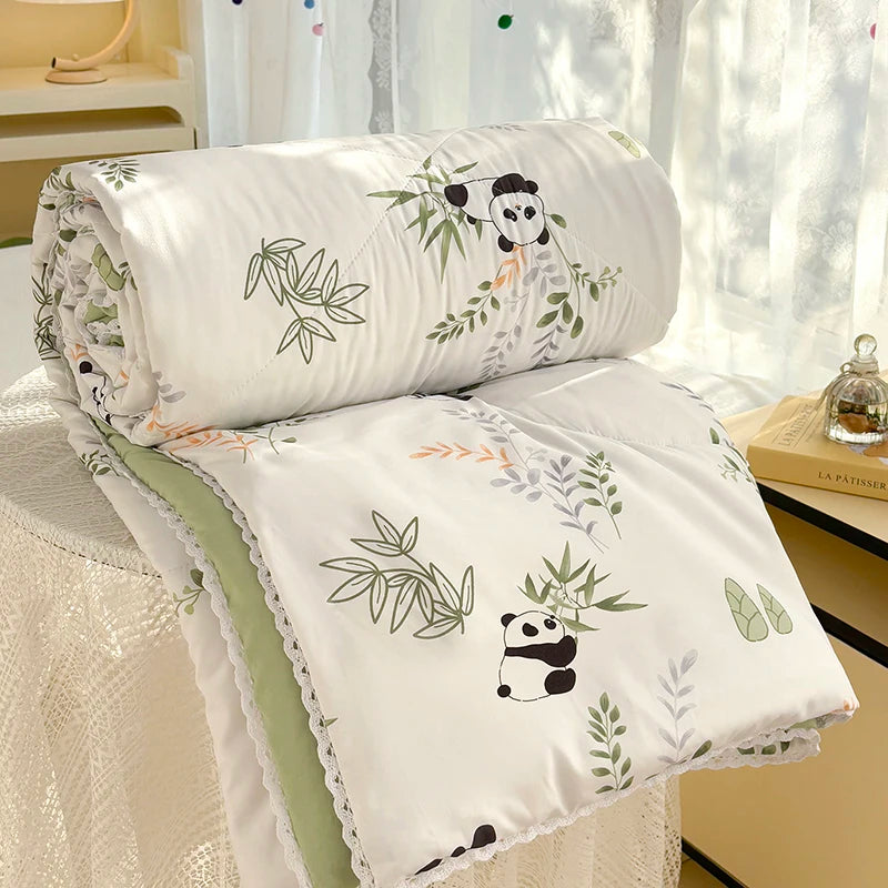 White comforter with a panda print featuring green foliage and lace trim