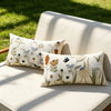 Three floral embroidered throw pillow covers featuring spring garden designs on a beige outdoor sofa.