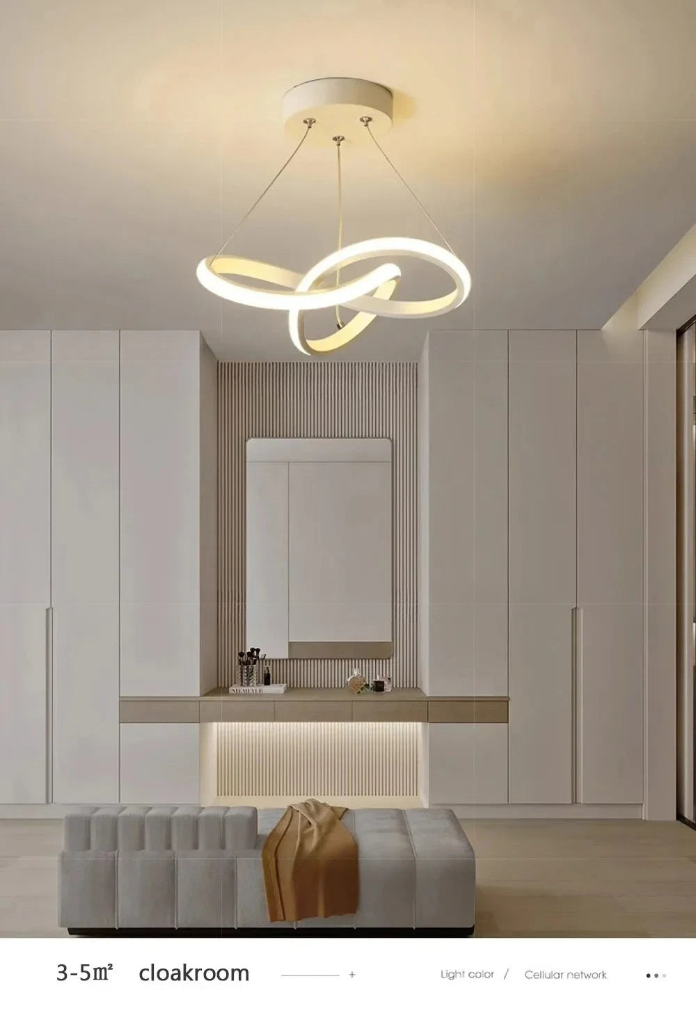 A modern pendant light fixture with a curved, glowing white design hangs above a minimalist counter in a light-colored room.