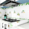 A roll of self-adhesive kitchen splashback sticker featuring green leaves and white tiles.