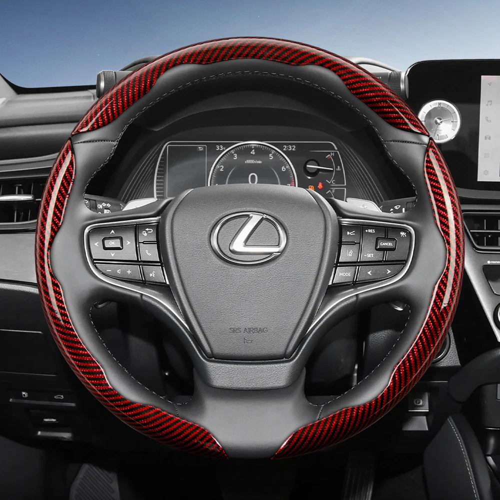 A black steering wheel with red carbon fiber texture accents and controls in a car interior.