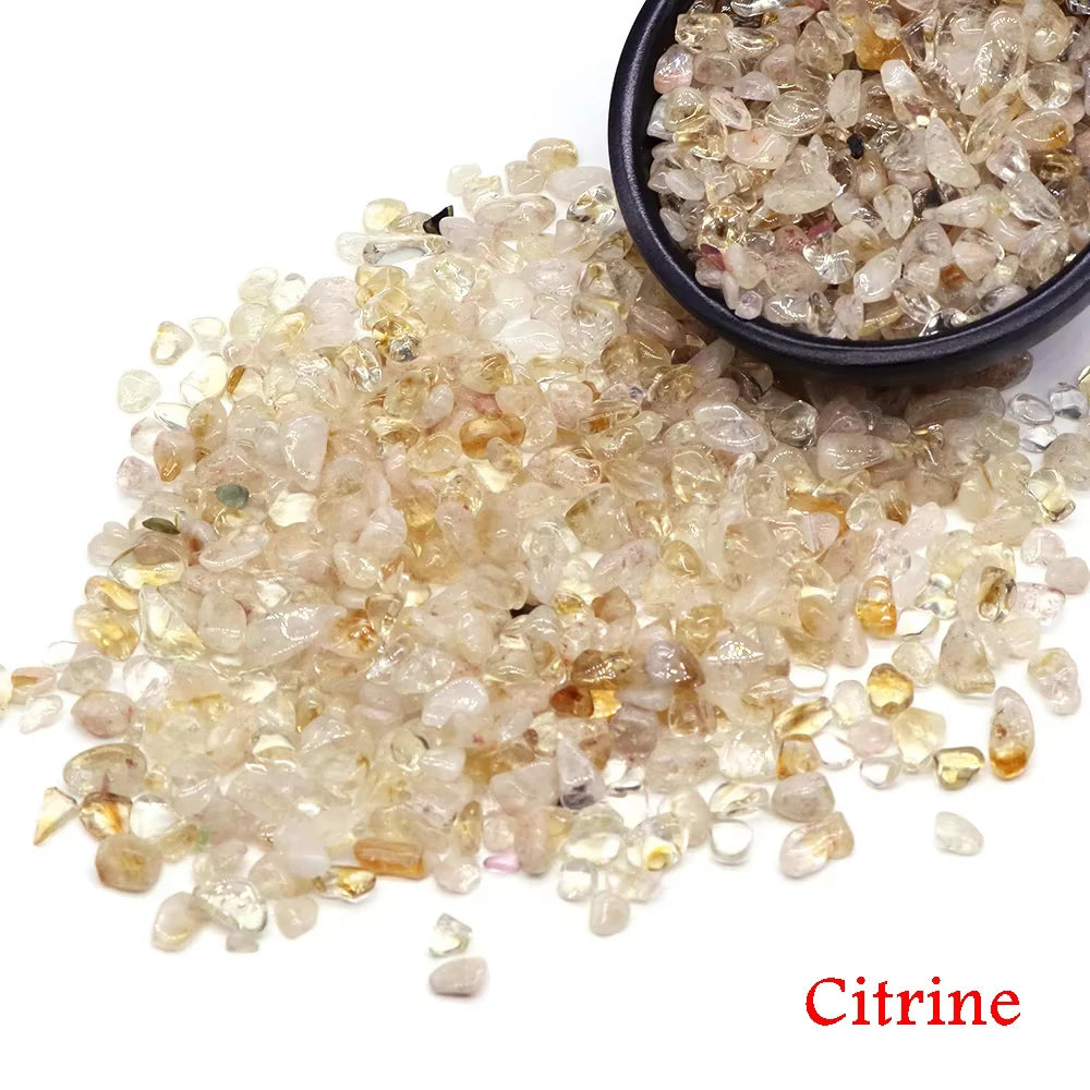A pile of natural citrine crystal stone chips in various shades of yellow and amber.