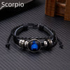 A black leather wrap bracelet featuring a glowing blue scorpion charm on a silver-toned metal base.