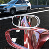A close-up view of a red car blind spot mirror reflecting the interior and surrounding environment.
