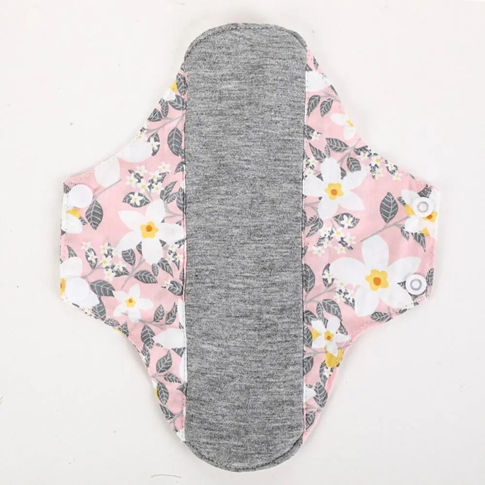 Reusable cotton menstrual pads with a pink floral pattern and a gray absorbent core.