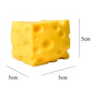 A yellow, cheese-shaped squishy stress relief toy with visible dimples.