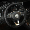 A black rhinestone steering wheel cover for a Mercedes vehicle interior.