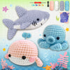 A collection of crocheted animal amigurumi toys including a shark, a blue elephant, and a pink and white sea creature.