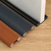 Rolls of flexible weather stripping and a white door blocker are shown on a wooden surface.