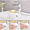 A chrome-plated sink overflow cover set is shown with a faucet and soap dishes on a white kitchen sink.