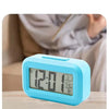 A light blue digital display showing time, temperature, and date functions on a compact LED desk lamp.