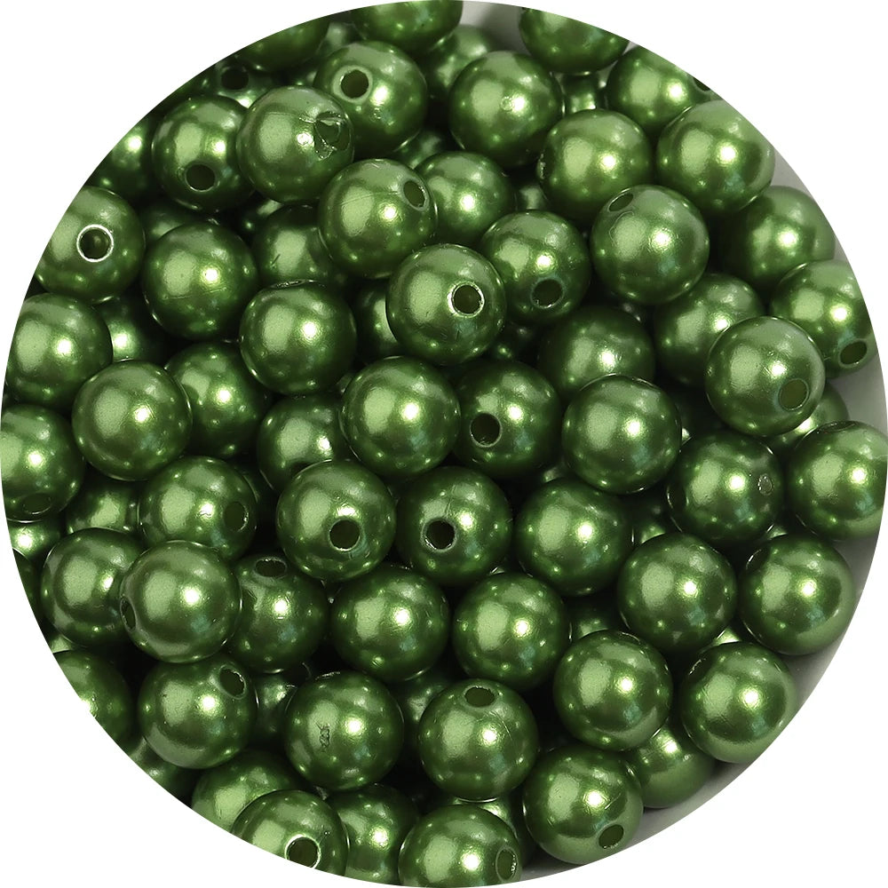 A pile of round, dark green ABS imitation pearl beads for jewelry making.