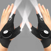 Pair of black waterproof LED half-finger gloves being used to illuminate a surface.