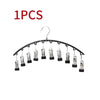 A set of ten metal pant hangers with clips hanging from a wire hanger.