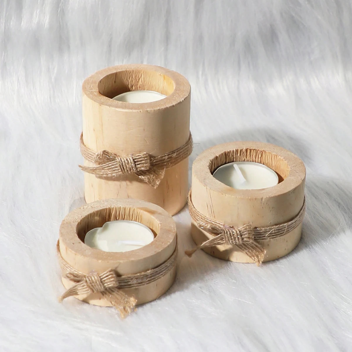 Rustic wooden tea light holder and mini flower pot wrapped with twine on a white fluffy surface