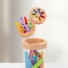 A wooden color matching bucket filled with various colored sticks and crayons for a color sorting game.