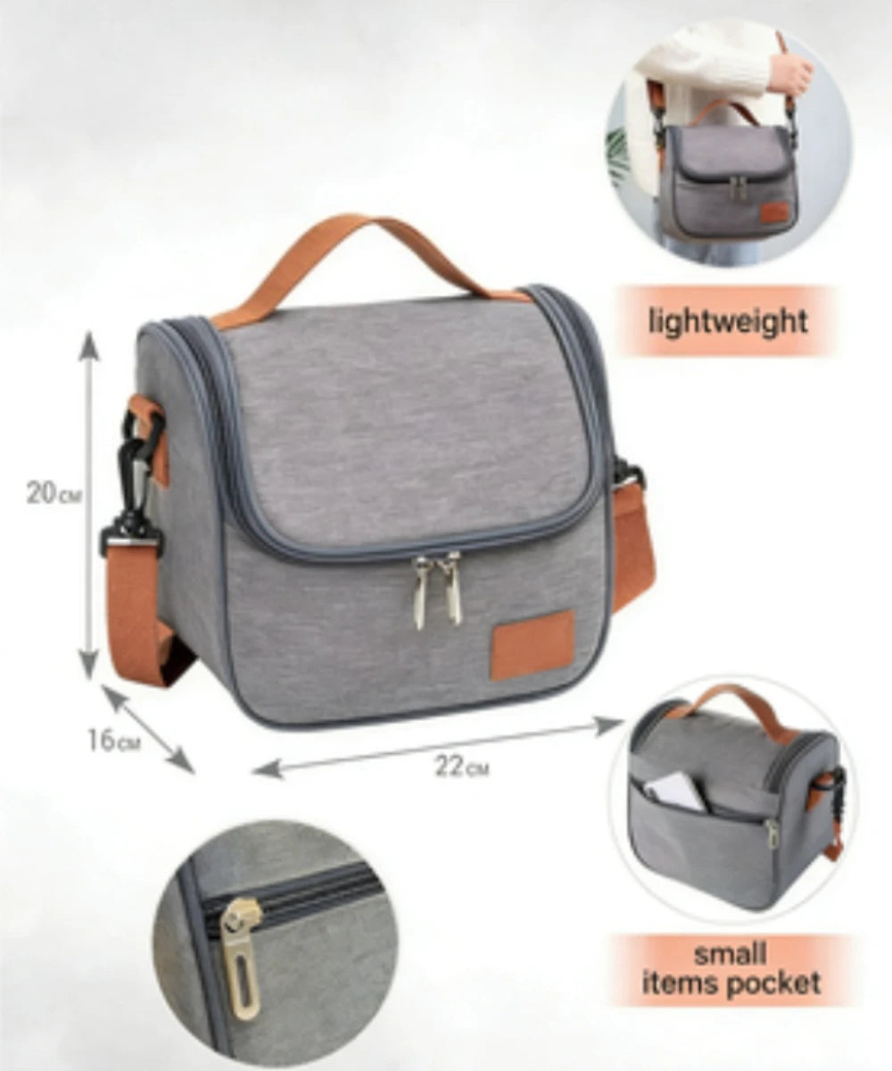Gray insulated lunch bag with brown strap and small pocket details