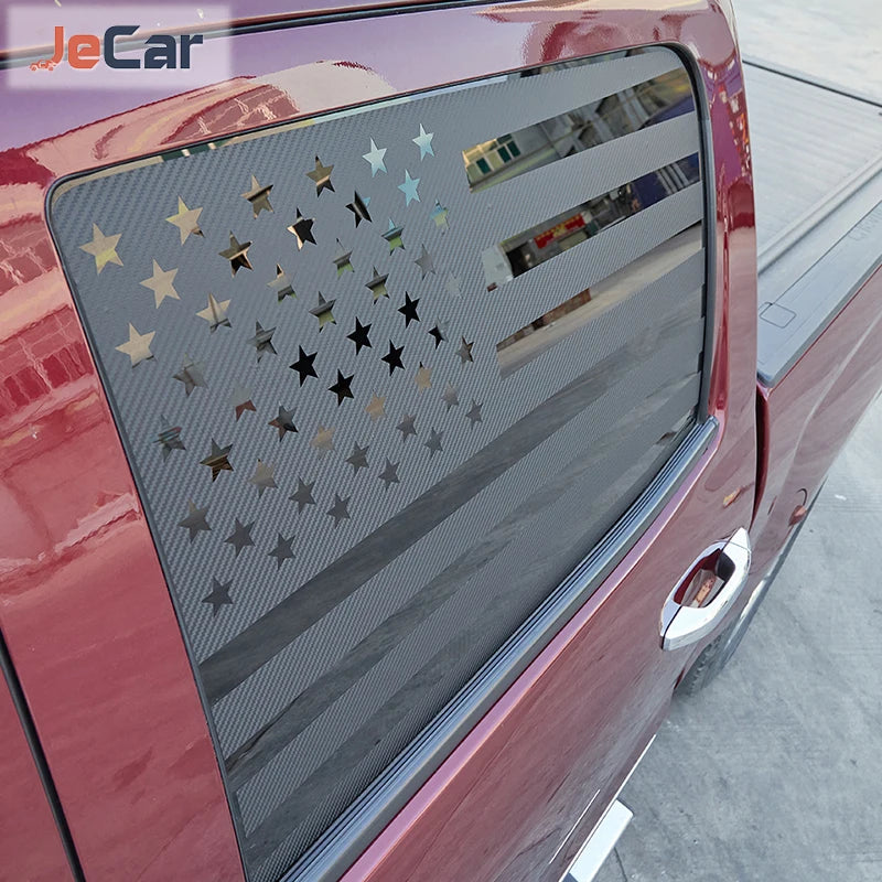 Close-up of a red truck's rear window with decorative star and geometric trim applied.