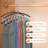 A display of stainless steel hangers with various colored fabric garments hanging on a wooden rod.