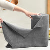 A hand is holding a roll of gray reusable microfiber cleaning wipes for kitchen use.