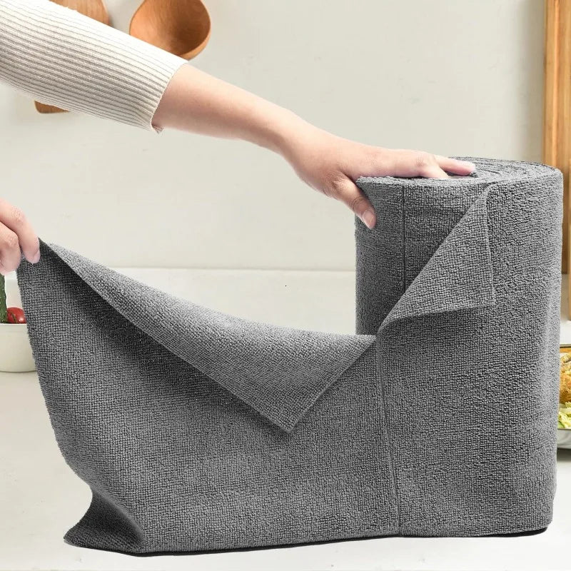 A hand is holding a roll of gray reusable microfiber cleaning wipes for kitchen use.