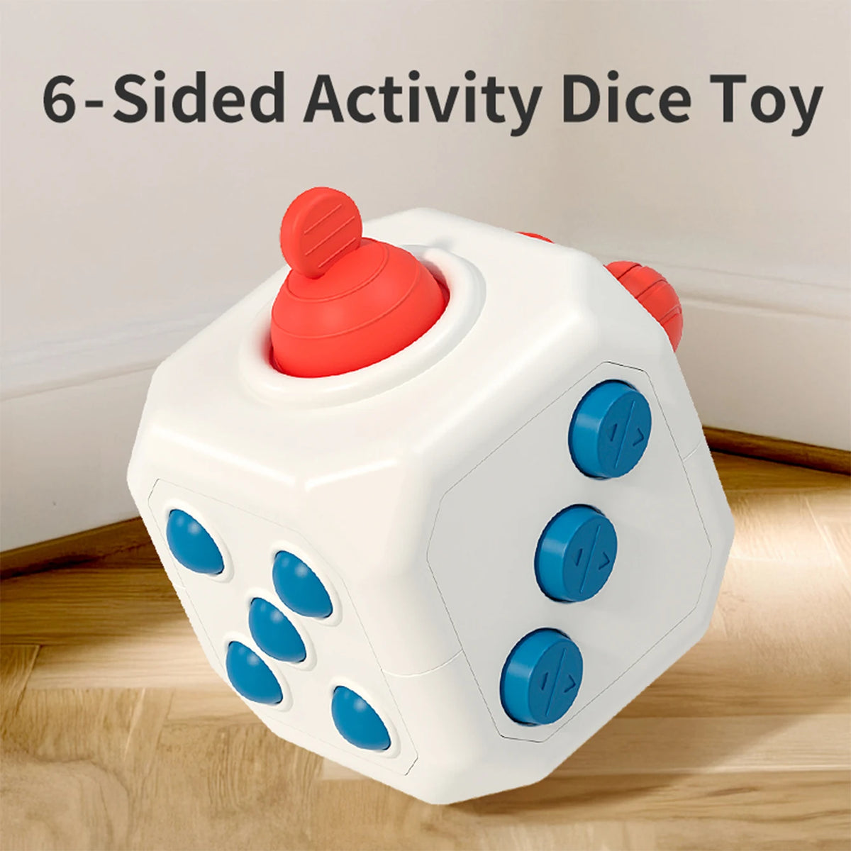 A white 6-sided activity dice toy with red and blue dots is shown on a wooden surface.
