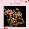 A miniature Japanese sakura tea house model featuring flowering branches and LED lighting effects.