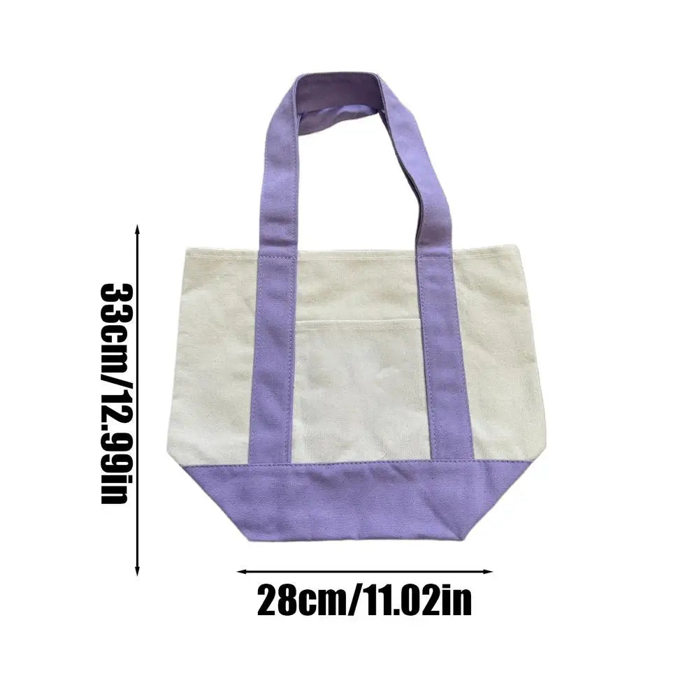 Una bolsa de lona con rayas moradas y crema, mostrada plana.