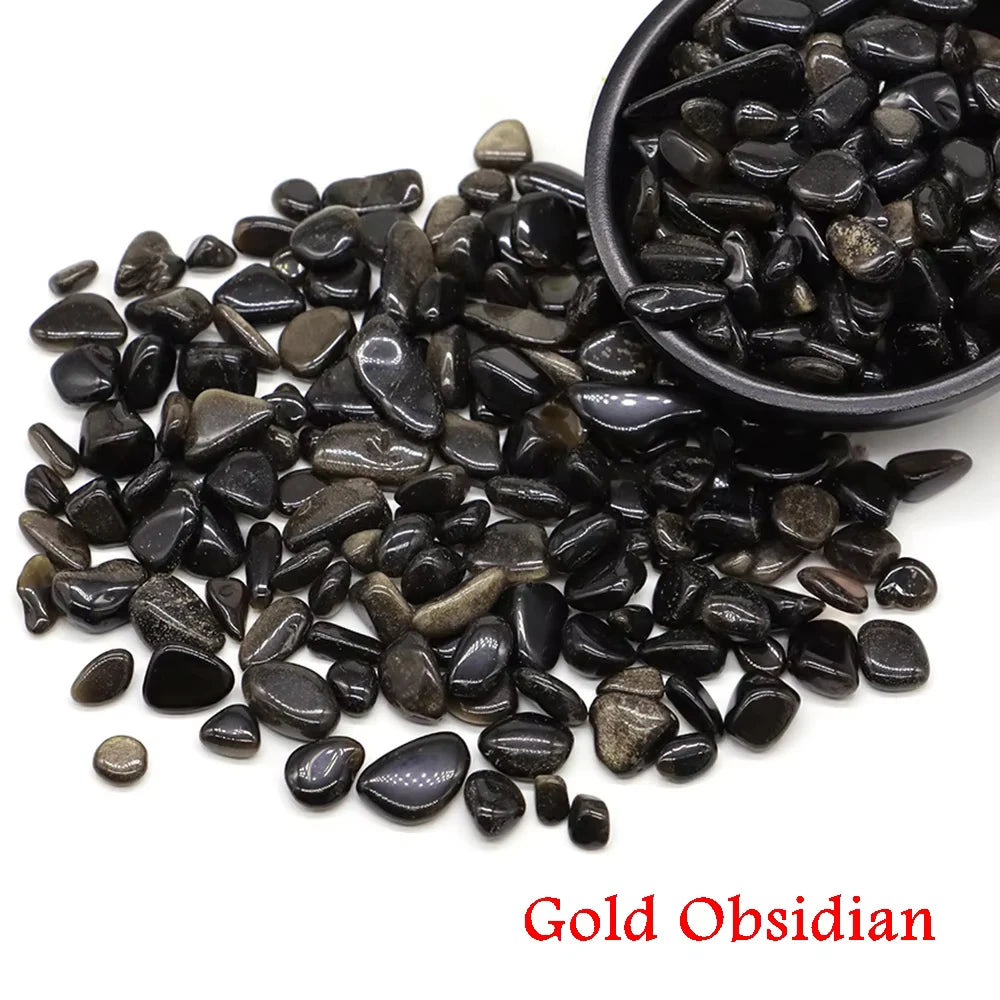 A pile of black Gold Obsidian tumbled crystal stone chips for healing and decor.