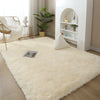 A fluffy cream colored rug in a modern living space with white furniture and indoor plants.