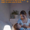 A soft light desk lamp with a pink base is illuminating a baby being cared for on a couch.