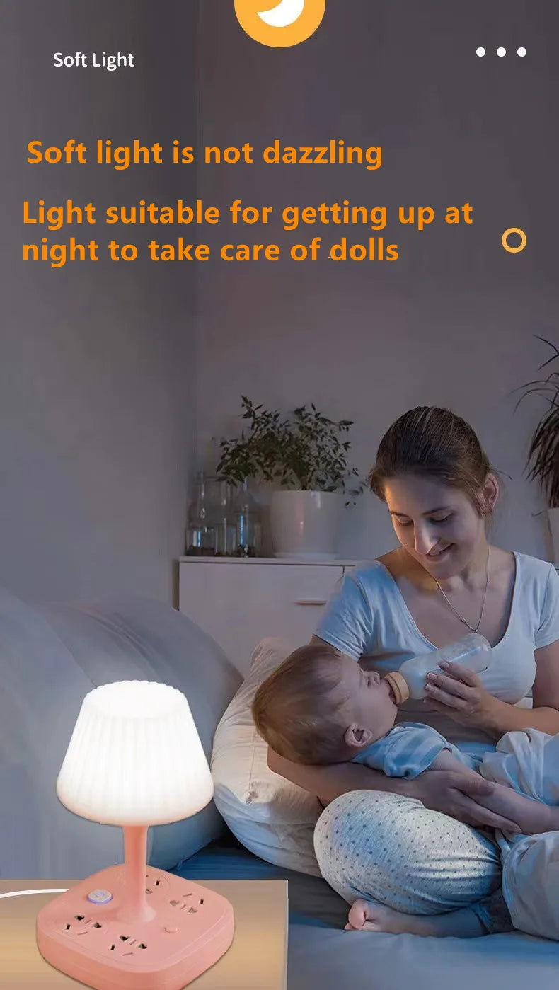 A soft light desk lamp with a pink base is illuminating a baby being cared for on a couch.