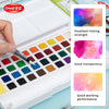 A watercolor paint set with various colors and water brush pens is shown in an open white case.