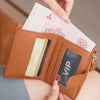 A hand is opening a brown leather bi-fold wallet showing various cards and a pink paper bill.