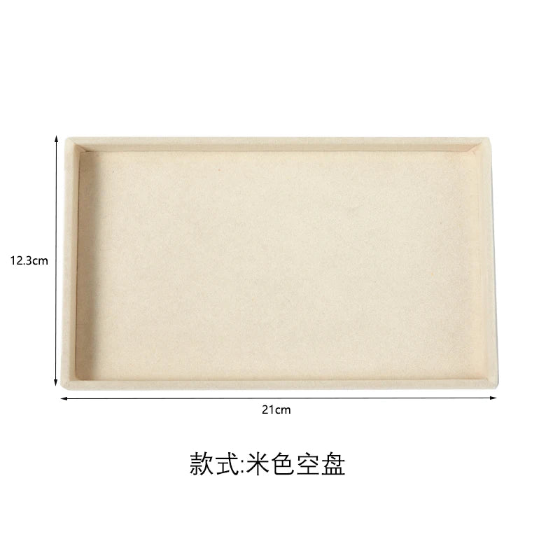 A rectangular light beige velvet jewelry organizer tray with a depth of 12.3cm and a length of 21cm.