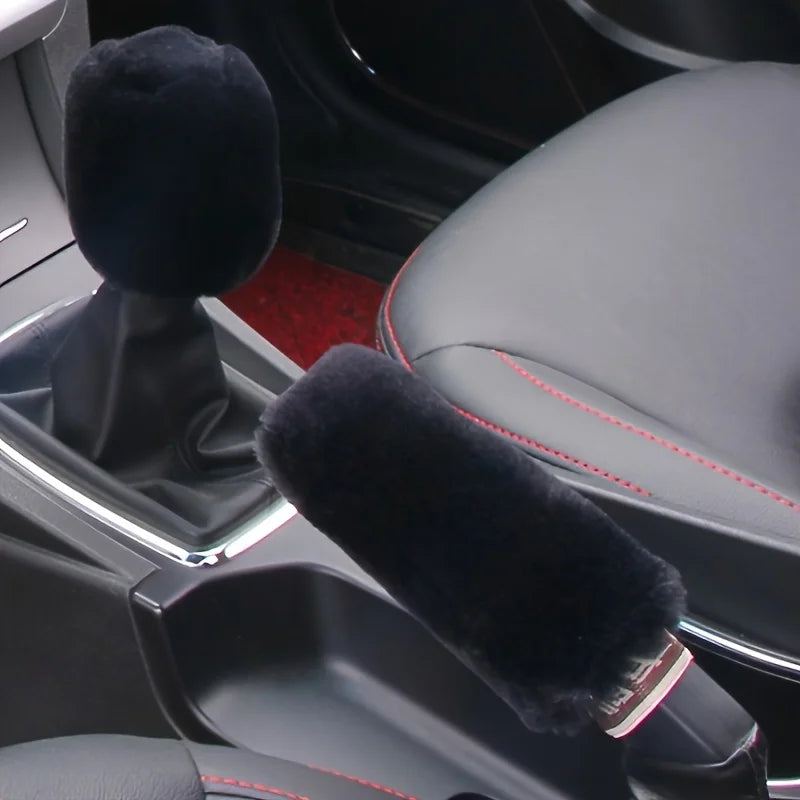 A close-up view of a plush black car gear shift and handbrake cover set inside a vehicle cabin.