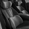 A close-up view of a black memory foam car headrest and lumbar support pillow in a vehicle seat.