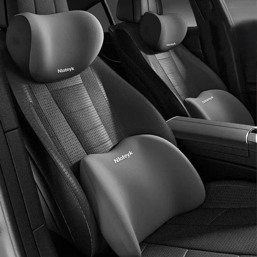 A close-up view of a black memory foam car headrest and lumbar support pillow in a vehicle seat.
