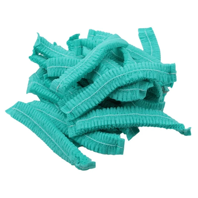 A pile of teal disposable non-woven hair net caps.