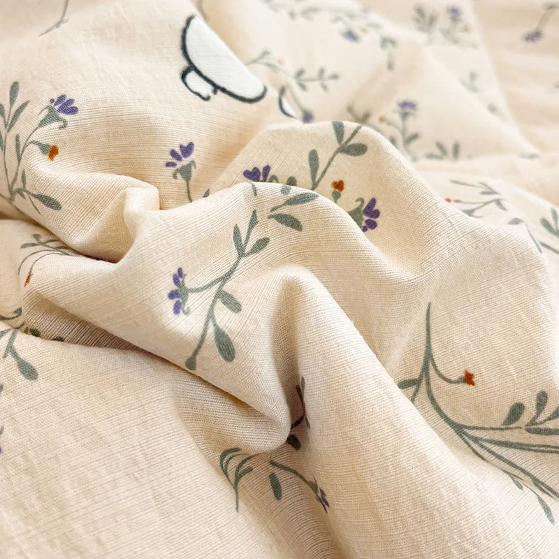 Light beige fabric with a subtle floral and animal pattern, folded to show texture.