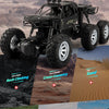 A black six-wheel drive off-road RC car is shown conquering various terrains like rock, sand, and snow.