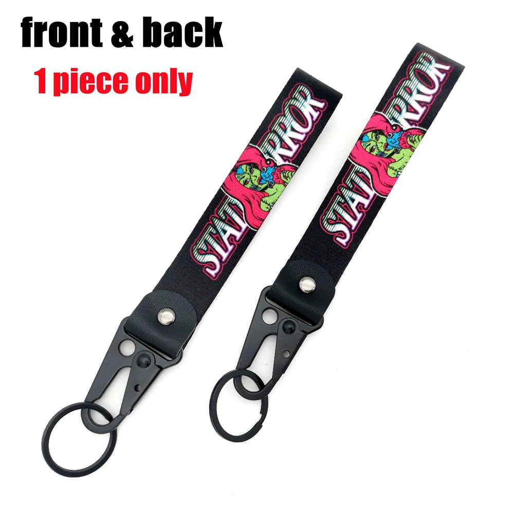 Front and back view of a black strap keychain featuring a pink and green anime girl design with a steel clip.