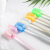 A collection of colorful protective toothbrush head covers with travel clips arranged on a white marble surface.