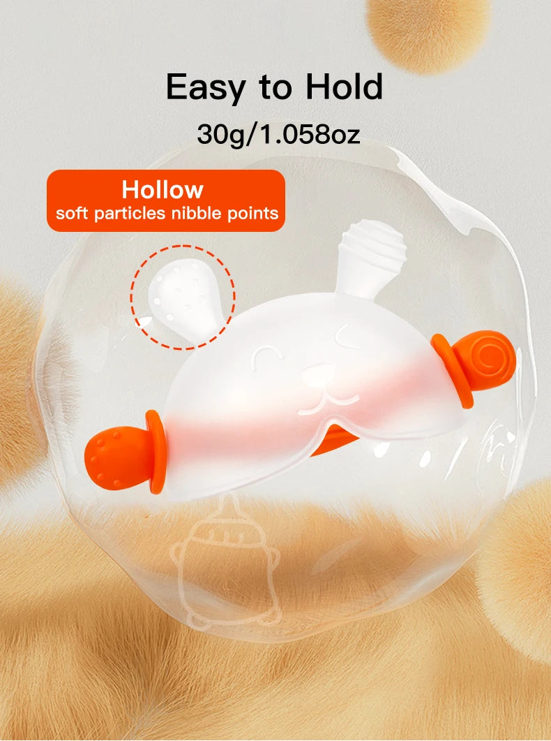 A clear silicone bunny-shaped baby teether with an orange handle is shown against a soft, fluffy background.