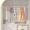 A bathroom interior showing a white vanity with a sink and a stainless steel tension shower curtain rod holding various color