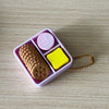 A pink plastic tray holds a brown fidget item and a yellow fidget item.